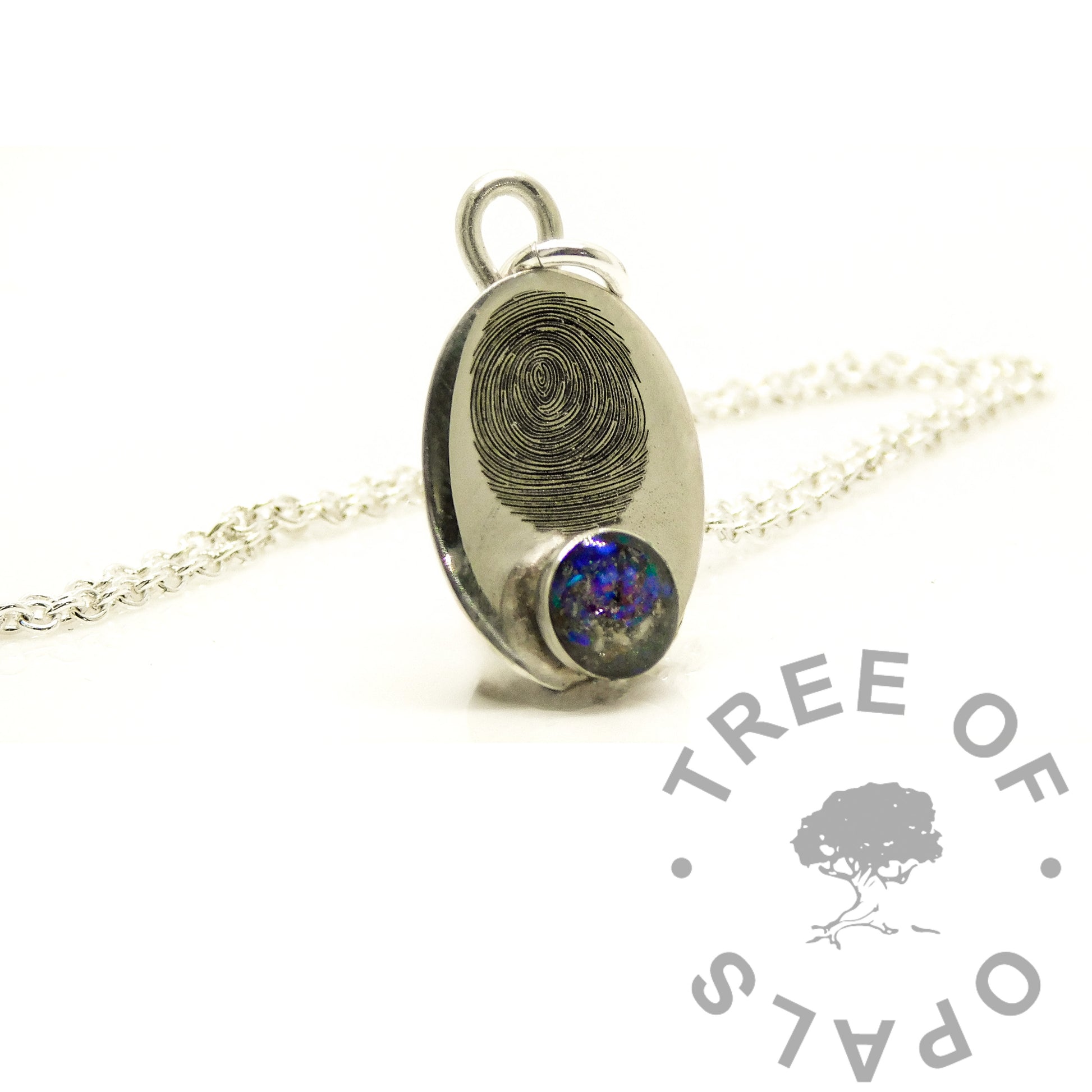 A silver oval pendant necklace featuring a fingerprint design on one side and a round blue opal gemstone on the other, displayed on a white background with a Tree of Opals logo watermark.