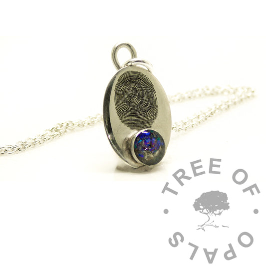 A silver oval pendant necklace featuring a fingerprint design on one side and a round blue opal gemstone on the other, displayed on a white background with a Tree of Opals logo watermark.