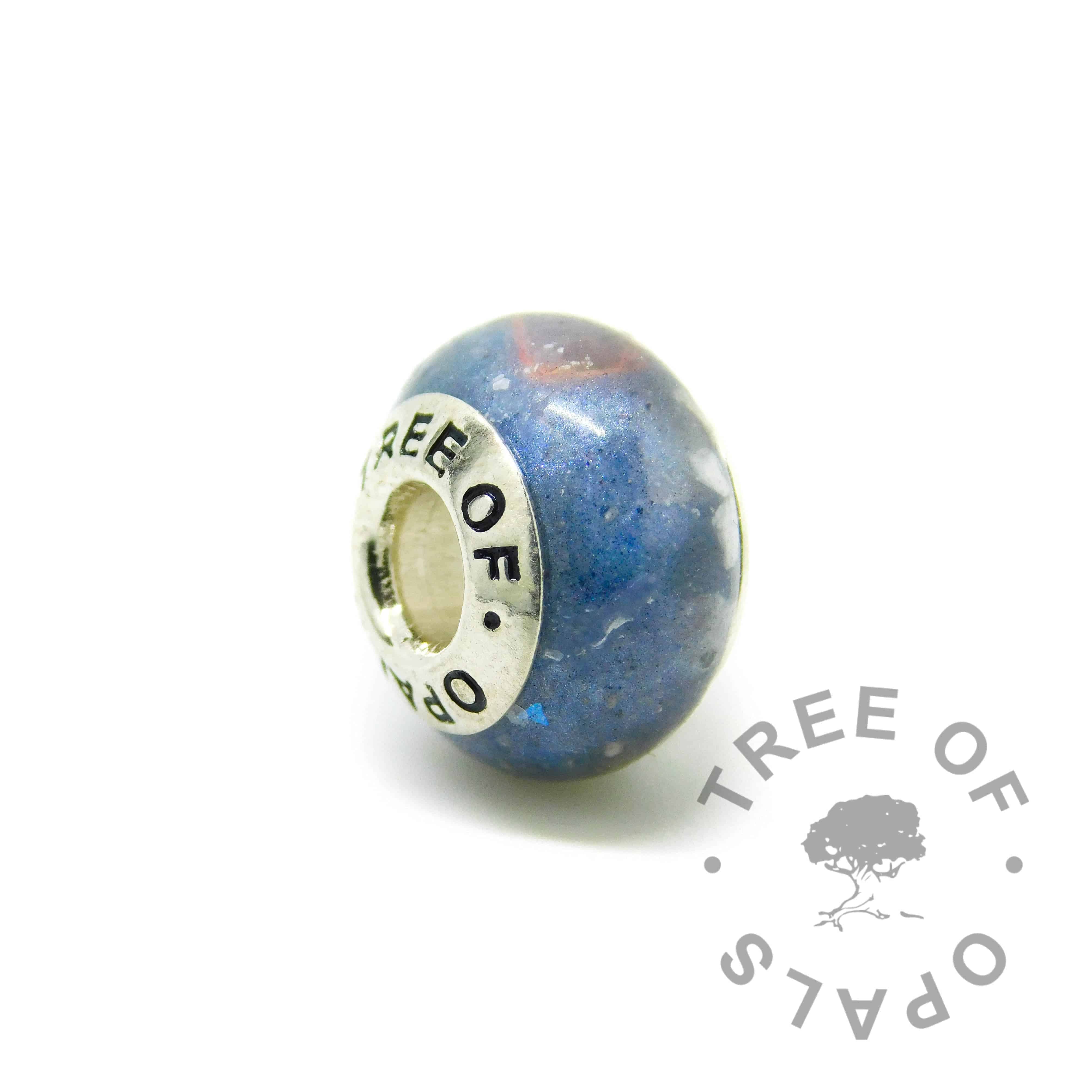 Cremation ash charm with deep blue resin sparkle mix (order Aegean blue, ask for specific colour in comments), rough natural crushed ruby July birthstone. Solid sterling silver Tree of Opals signature core (925 stamped on the back). Watermarked copyright Tree of Opals memorial jewellery image