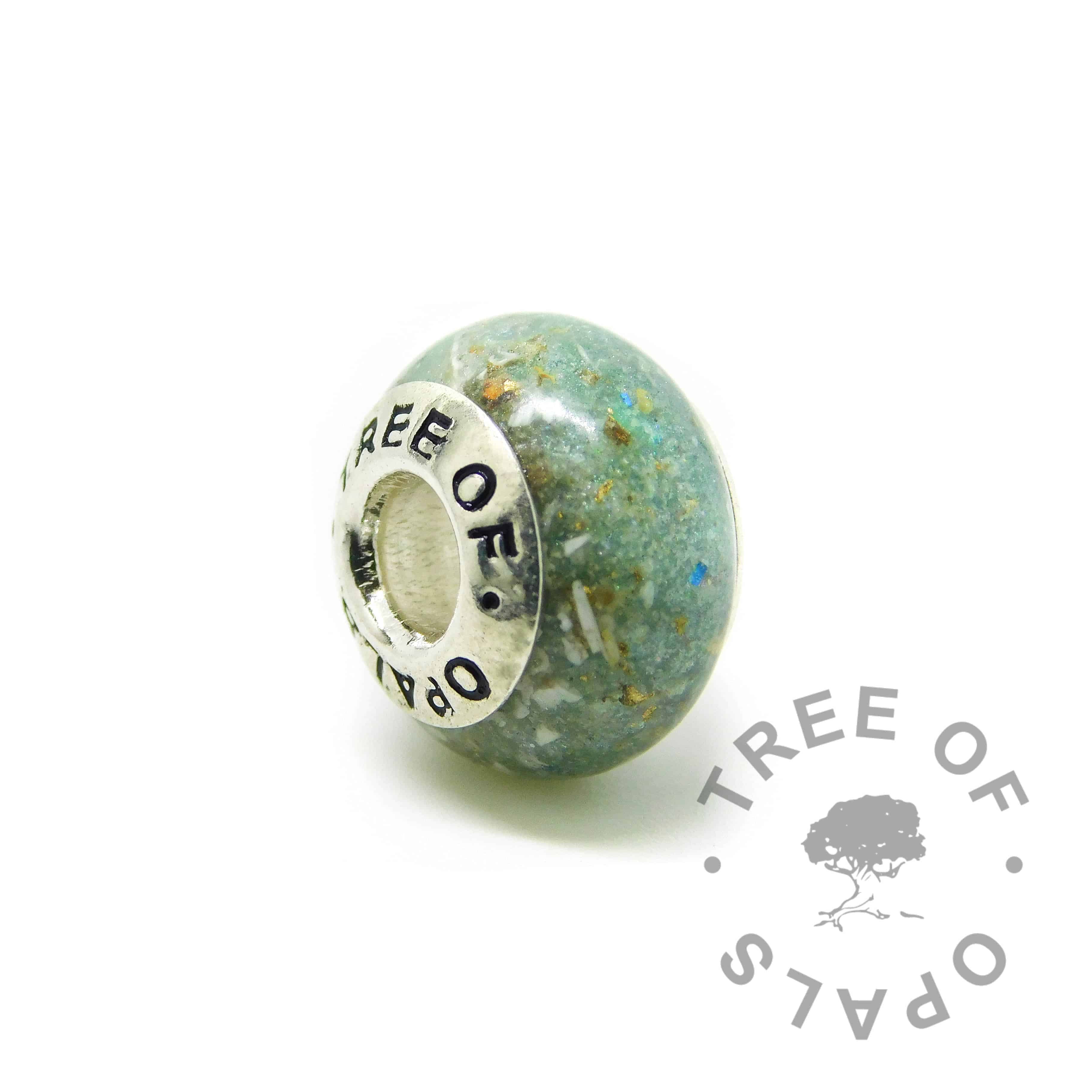 Cremation ash charm with basilisk green resin sparkle mix, no birthstone, gold leaf. Solid sterling silver Tree of Opals signature core (925 stamped on the back). Watermarked copyright Tree of Opals memorial jewellery image