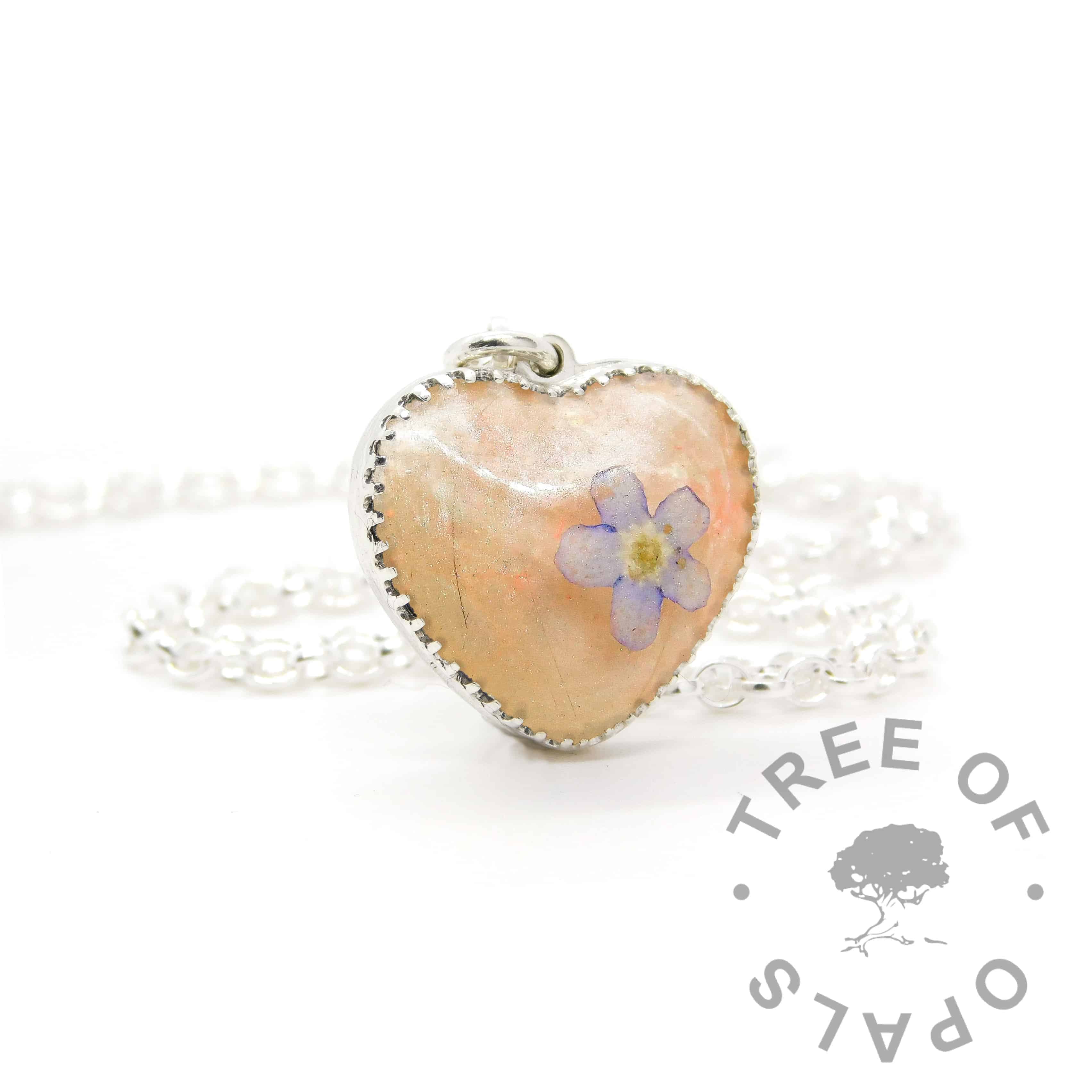 New style heart necklace setting with scalloped edge. Fairy pink resin sparkle mix, lock of hair, shaped forget me not, shown with a medium classic chain upgrade (mockup of new setting). Remember that "white hair" is often translucent in resin!