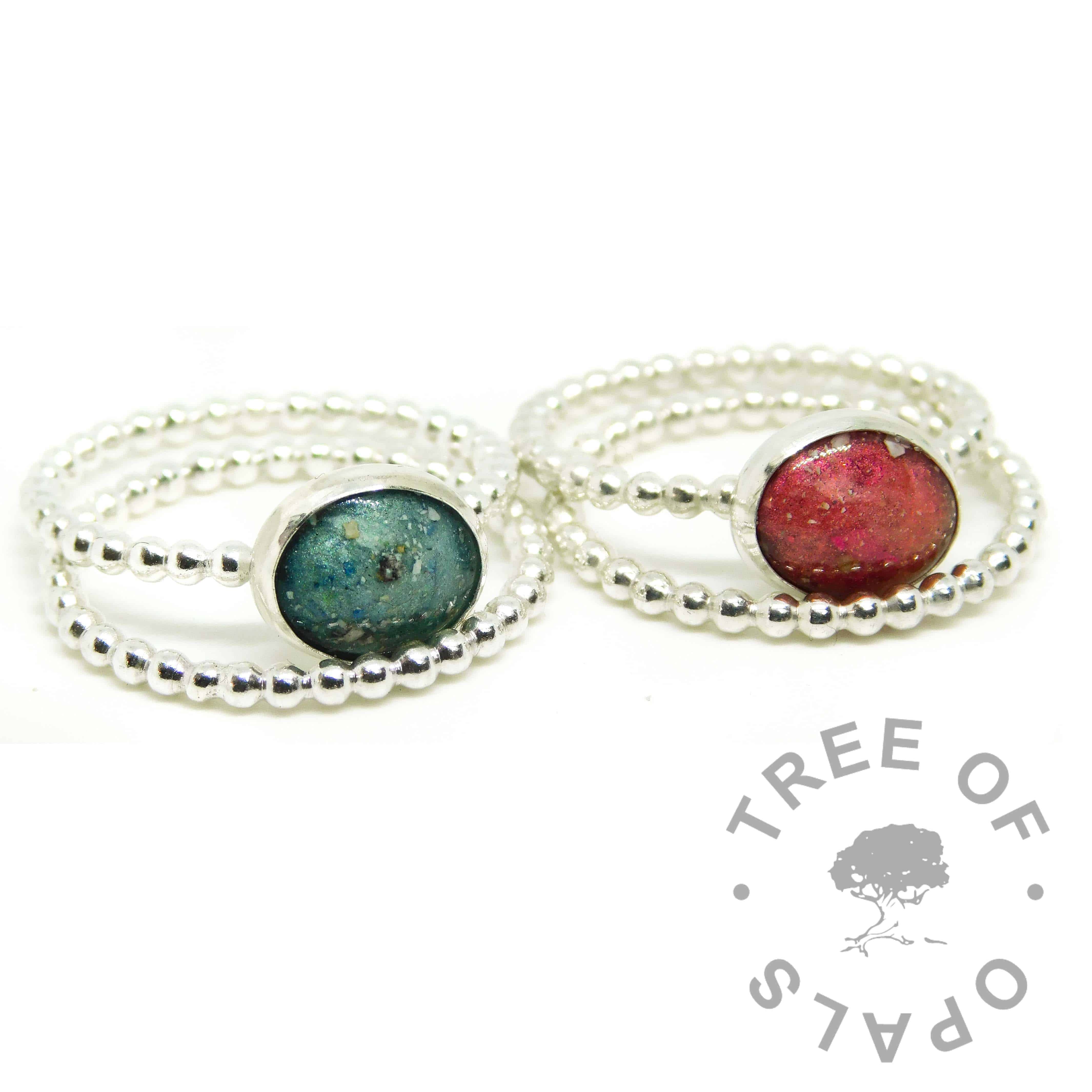 red and teal ashes ring duo, dragon's blood red and mermaid teal resin sparkle mixes, bubble wire Argentium silver bands. Shown with bubble wire slim stacking bands