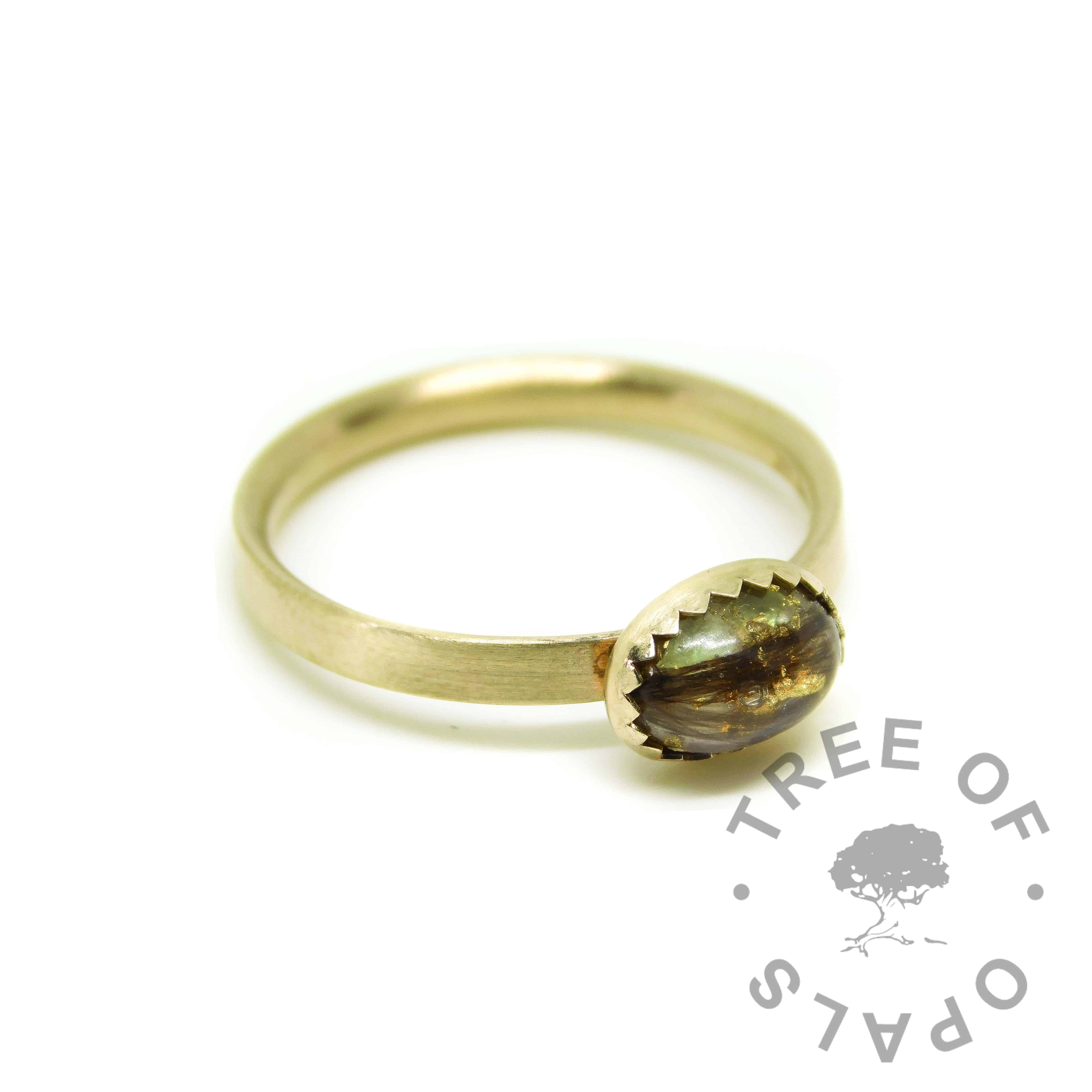 Solid gold lock of hair ring with unicorn white resin sparkle mix and August birthstone rough natural peridot, and gold leaf. Brushed band gold ring solid 14ct gold with serrated setting