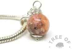 cremation ash pearl with tangerine orange sparkles and opal on a European dangle charm setting for Pandora bracelets shown on a 3mm wide snake chain bracelet upgrade or necklace upgrade. Pearl and chain sold seperately