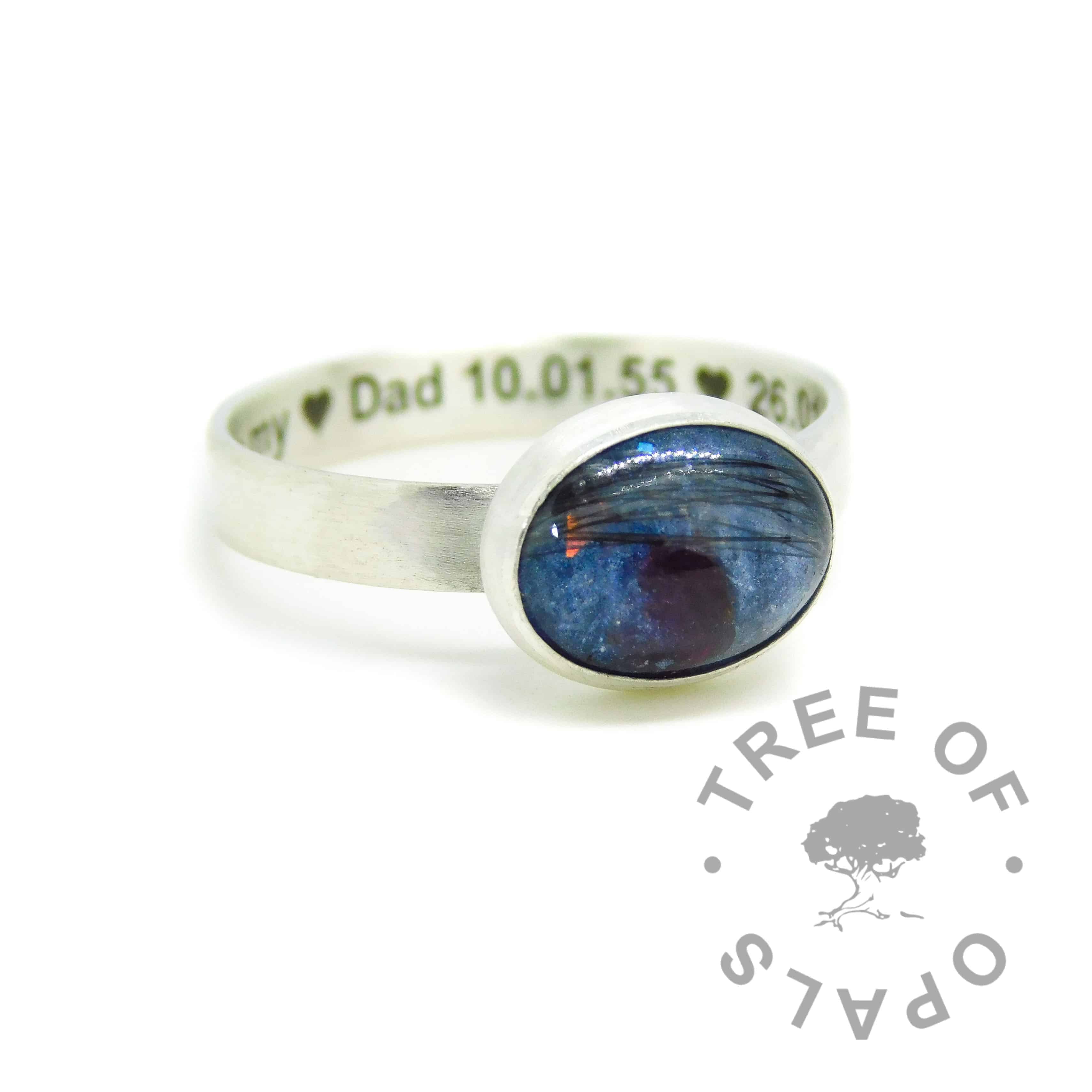 Engraved brushed band lock of hair ring with Aegean blue resin sparkle mix and salt and pepper grey hair, with January birthstone red garnet. Engraved inside in Arial font and hearts. Handmade solid sterling silver memorial ring
