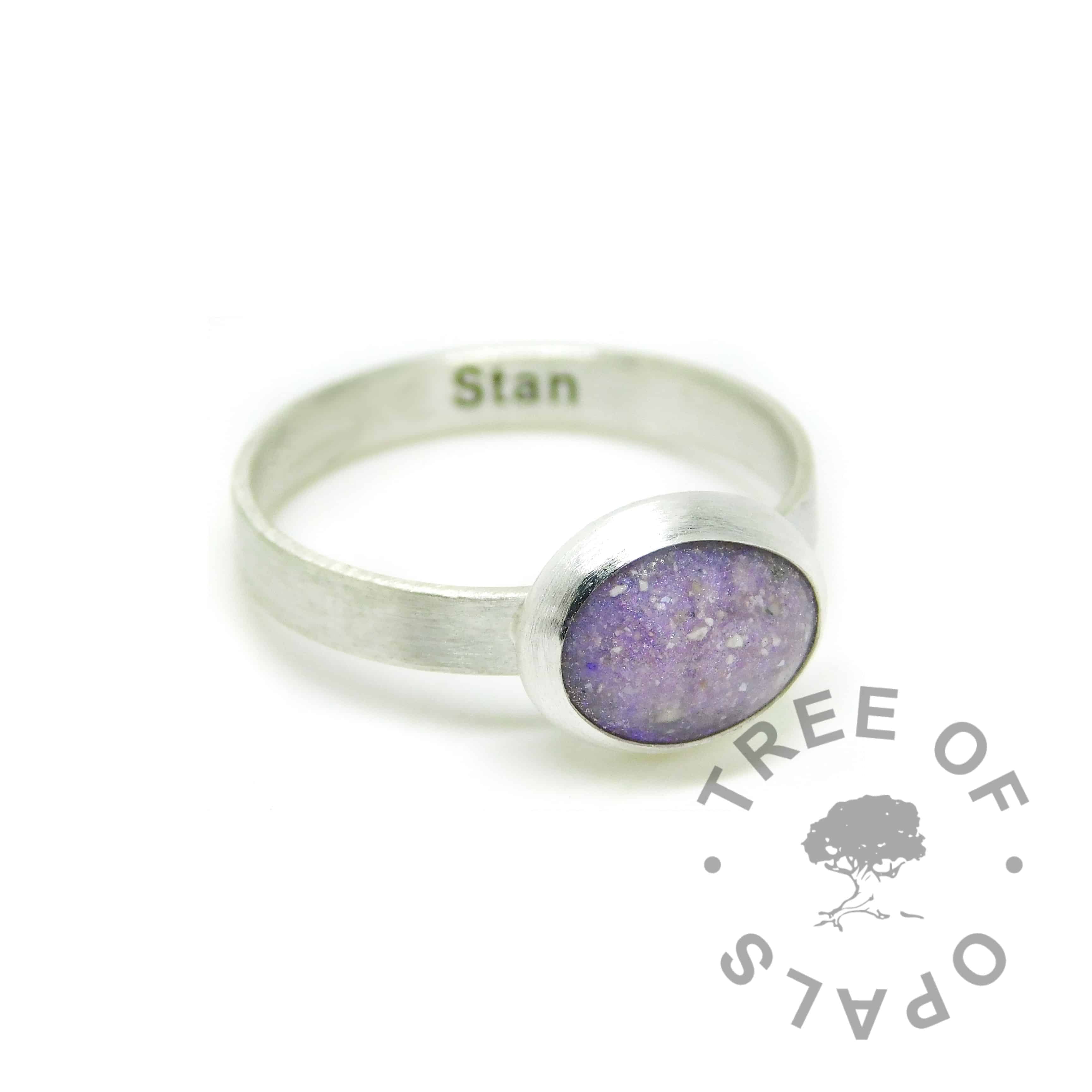 orchid purple cremation ash ring on a brushed wire band . Solid 925 sterling EcoSilver handmade ring. Cremains ring with engraved text on the inside of the band, in Arial font (some text removed for privacy). 10x8mm bezel cup rubbed over the cabochon for security.