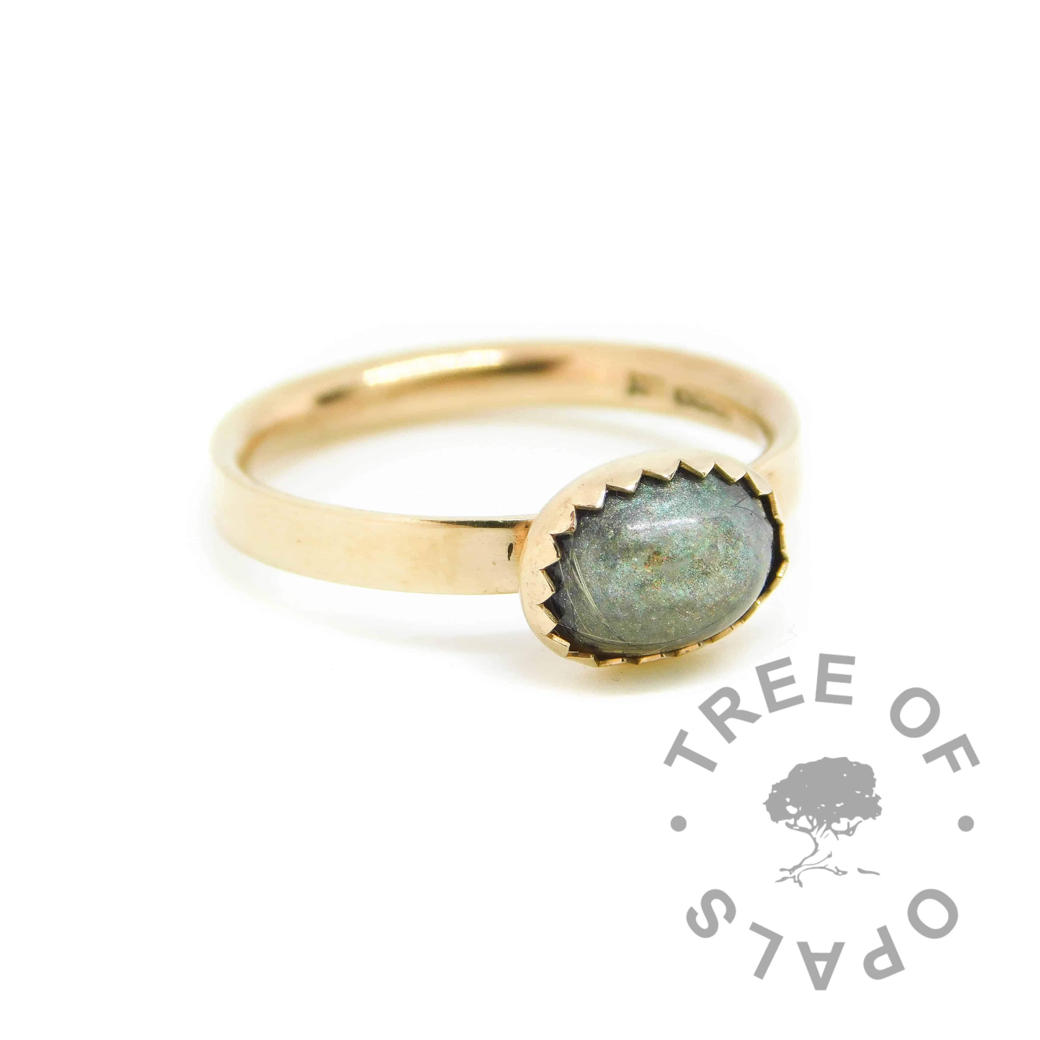 14ct gold fur ring with mermaid teal resin sparkle mix, no birthstone. Brushed ring band handformed with solid 14ct gold, and 8x6mm serrated bezel cup. Hallmarked with Tree of Opals maker's mark at The Birmingham Assay Office. Watermarked copyright Tree of Opals memorial jewellery image