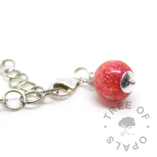 bottom view of a dragon's blood red cremation dangle charm with solid sterling silver lobster claw setting for Thomas Sabo style bracelets and necklaces Tree of Opals