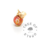 gold ashes orb with dragon's blood red resin sparkle mix, white forget me not, rose gold leaf and cremation ashes. Set with 9ct yellow gold headpin and European dangle charm tube