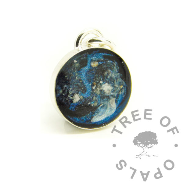 galaxy ashes necklace, 10mm round handmade classic round bezel setting. Solid sterling silver 925 setting with direct pour UV resin. Galaxy effect with vampire black resin sparkle mix background, swirled Aegean blue and unicorn white and small pieces of ash for stars. Perfect for memorial designs with epoxy or UV resin, cremation ashes and hair or fur, even breastmilk and umbilical cord. mystery piece