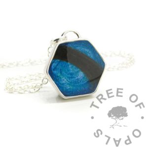 hexagonal hair necklace, lock of hair placed across the pendant. Aegean blue resin sparkle mix background. Handmade solid anti-tarnish silver setting shown with chain
